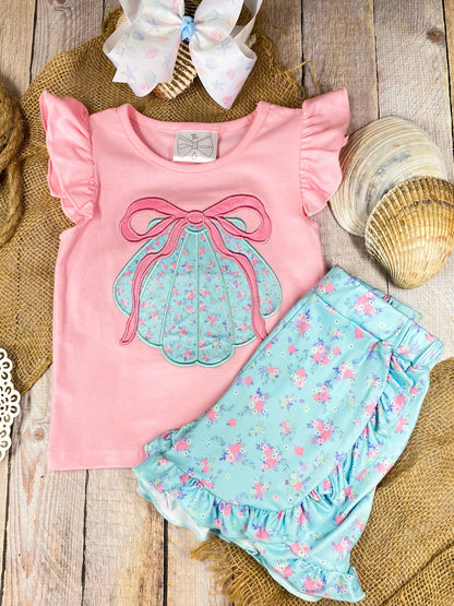 Girls sea shell outfit with pink top and blue shorts on a wooden background