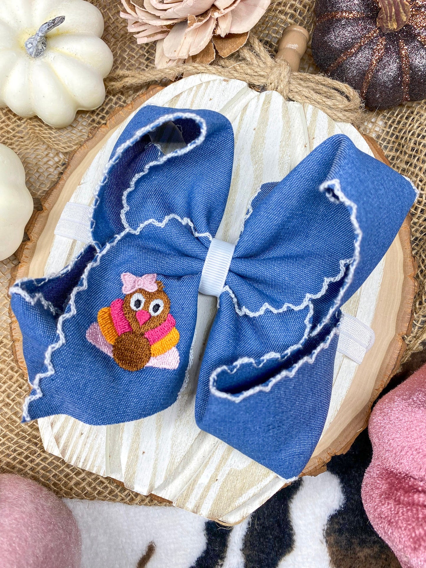 Pink Turkey Moonstitch Headband on Denim Hair Bow on a wooden background
