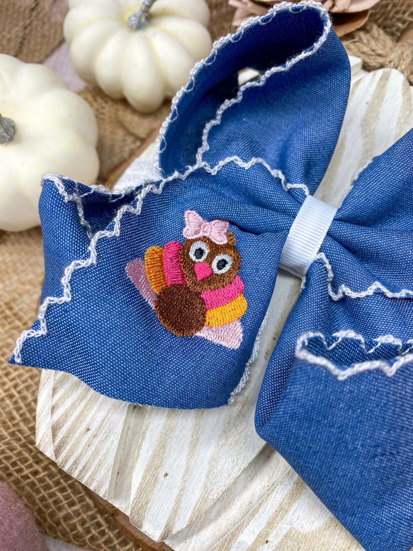 Pink Turkey Moonstitch Headband on Denim Hair Bow on a wooden background