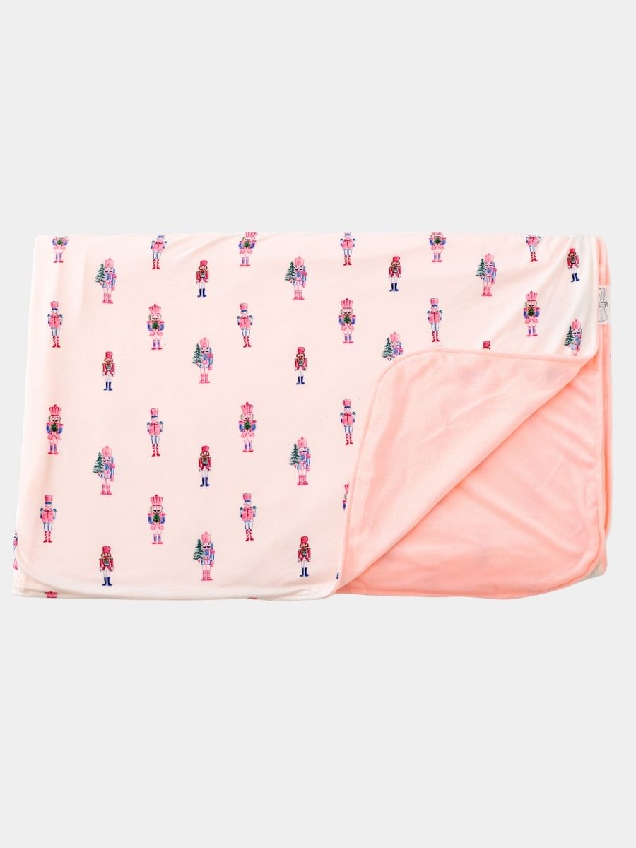 Pink Nutcracker Christmas minky baby blanket featuring a pastel nutcracker print with ultra-soft blush plush minky backing.