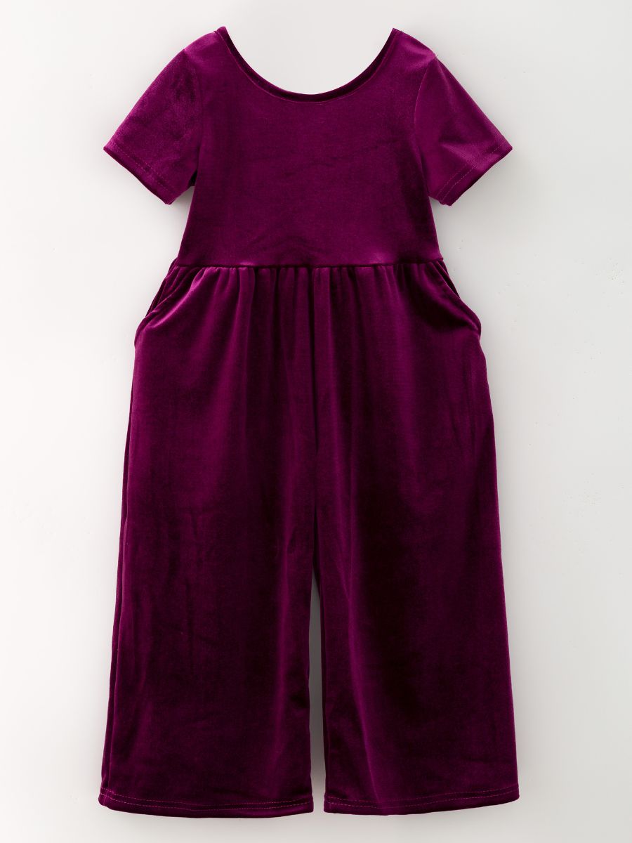 Plum girls’ velvet wide-leg jumpsuit with short sleeves and side pockets.