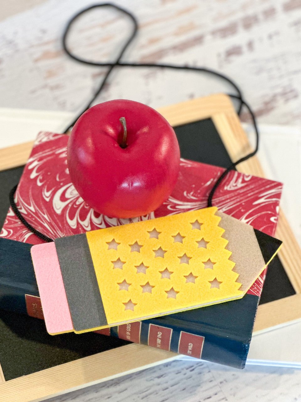 Felt crossbody purse accessory in the shape of a pencil.