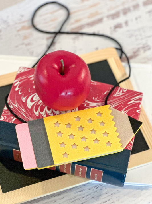 Felt crossbody purse accessory in the shape of a pencil.