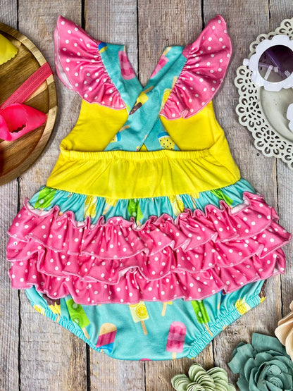 Colorful baby romper with ice cream pattern on a wooden background