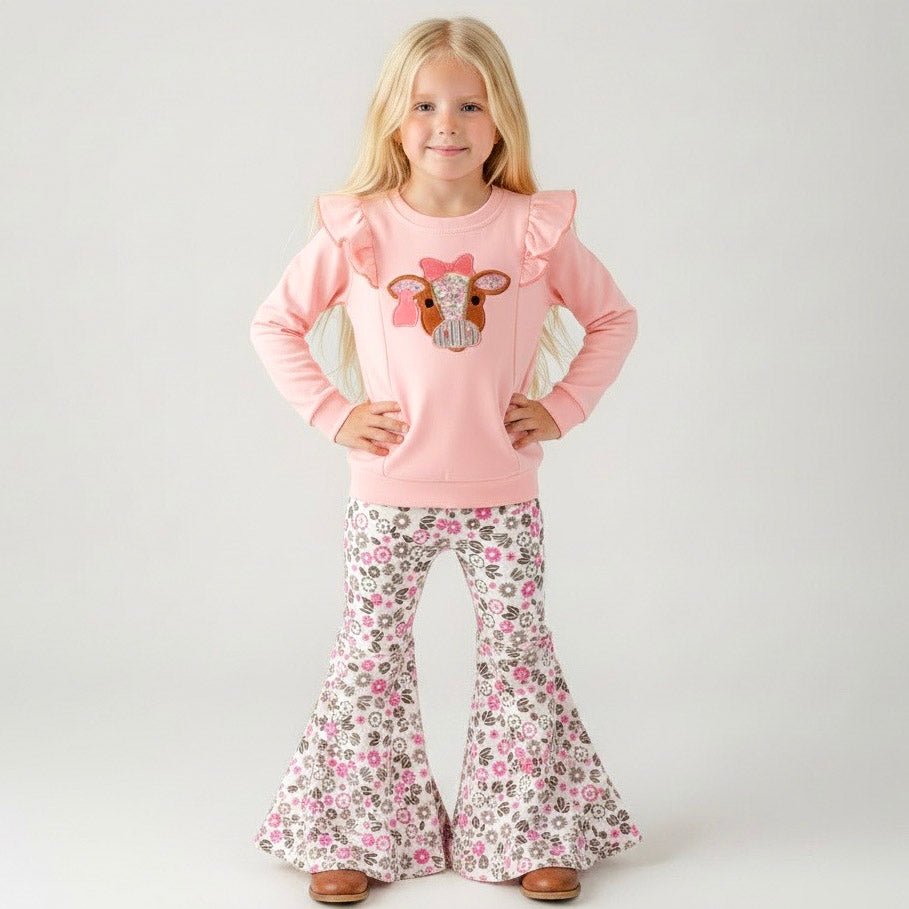 girl wearing a western two-piece with cow appliqué ruffle sweatshirt and pink floral bell bottoms