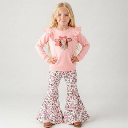 girl wearing a western two-piece with cow appliqué ruffle sweatshirt and pink floral bell bottoms