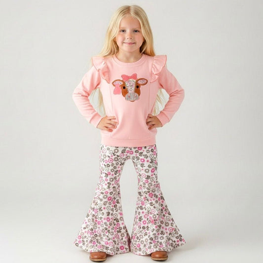 girl wearing a western two-piece with cow appliqué ruffle sweatshirt and pink floral bell bottoms