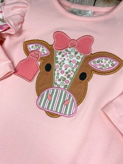 baby girl western one-piece with floral cow appliqué and layered floral ruffle leg hems on a wooden background