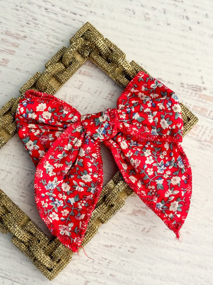 Red floral print bow with a removable single alligator clip. Measures approximately 5x5 inches.
