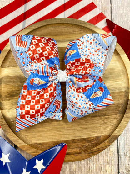 Red White & Blue Patchwork hairbow on a wooden surface