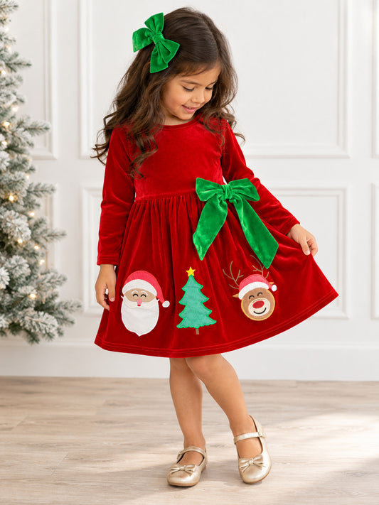 festive red velvet dress with green bow accents and Santa-themed appliques on a model
