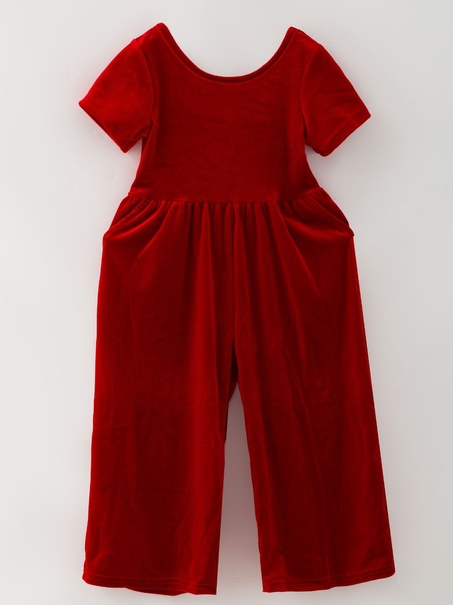 Red girls’ velvet holiday jumpsuit with wide legs, short sleeves and side pockets.