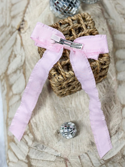 Back of pink ruffle edge ribbon hair bow showing alligator clip