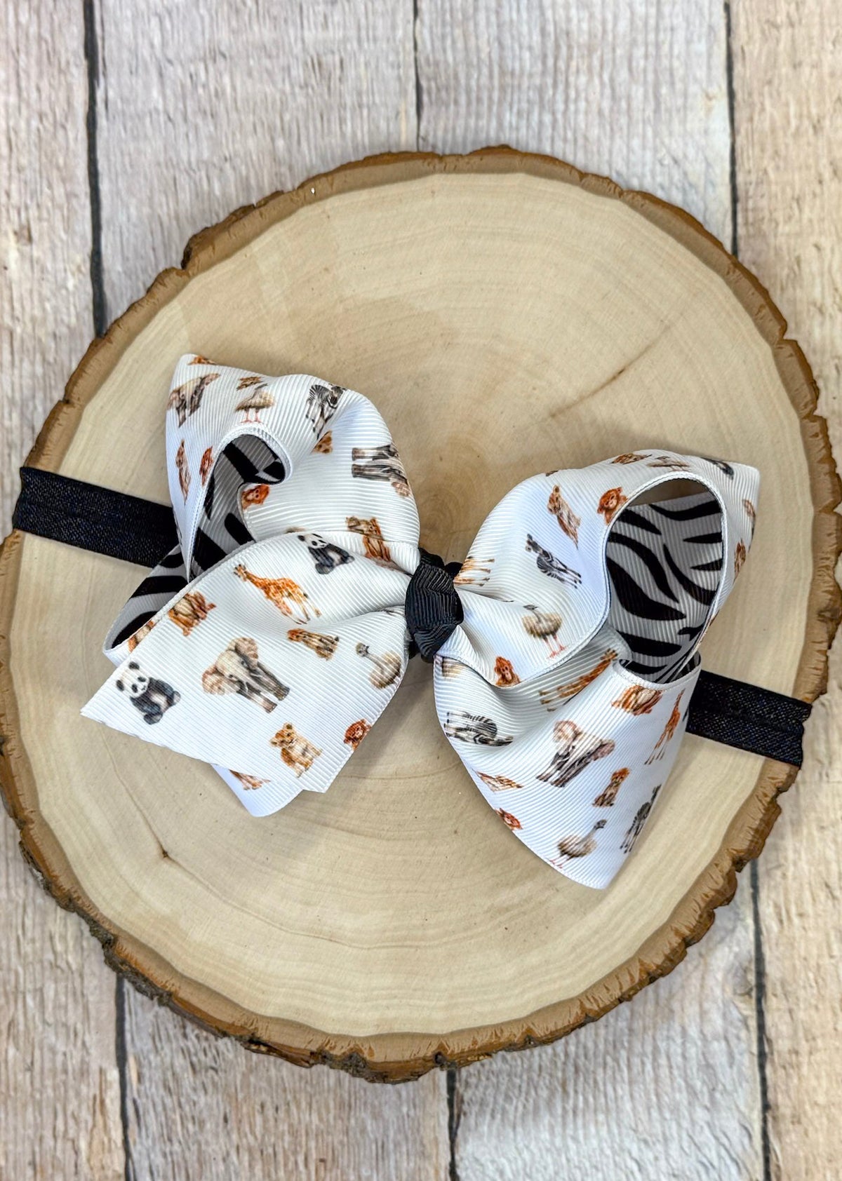 Safari zoo animal print bow headband on a wooden surface
