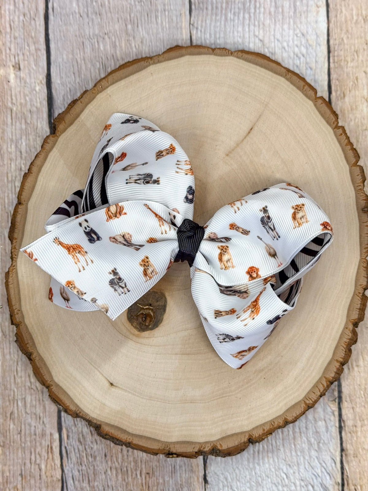 Safari zoo animal print hair bow on a wooden surface