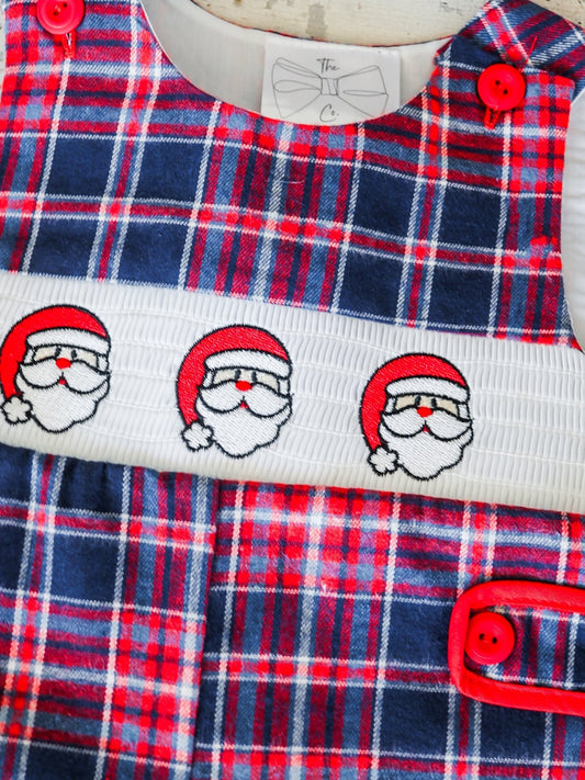 Close-up of embroidered Santa faces and red buttons on a plaid infant onesie - Alternative view