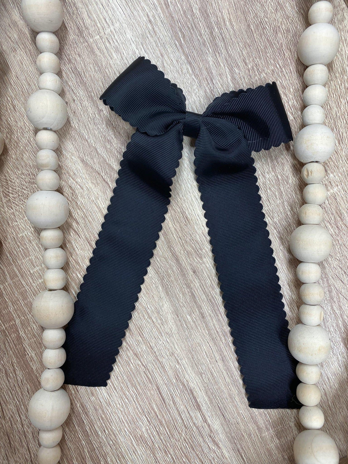 Black scalloped long tail hair bow on alligator clip