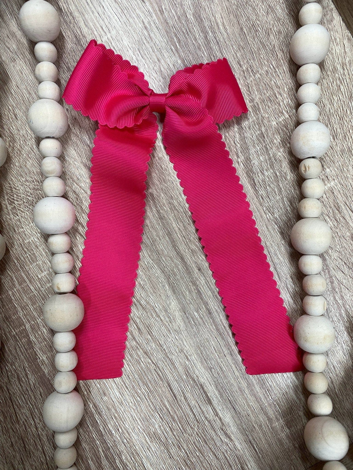 Hot pink scalloped long tail hair bow on alligator clip