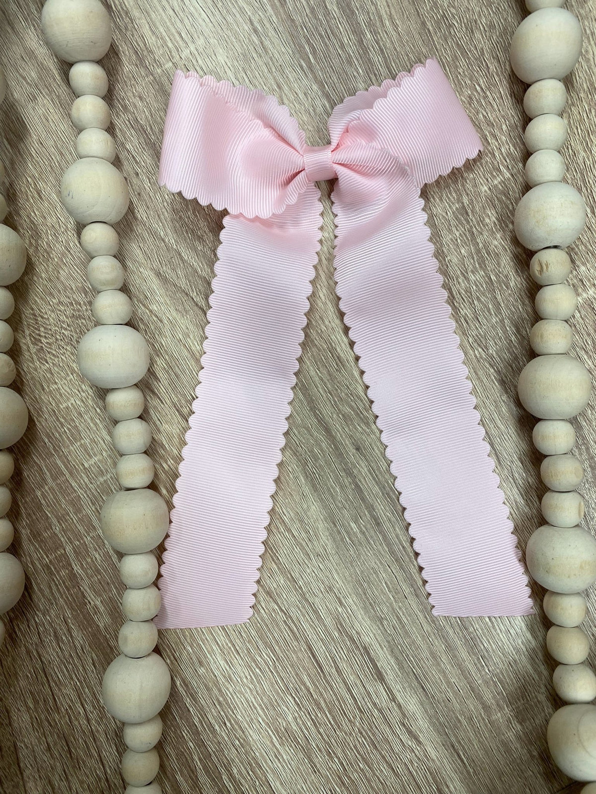 Light pink scalloped long tail hair bow on alligator clip
