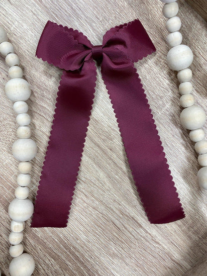 Maroon scalloped long tail hair bow on alligator clip