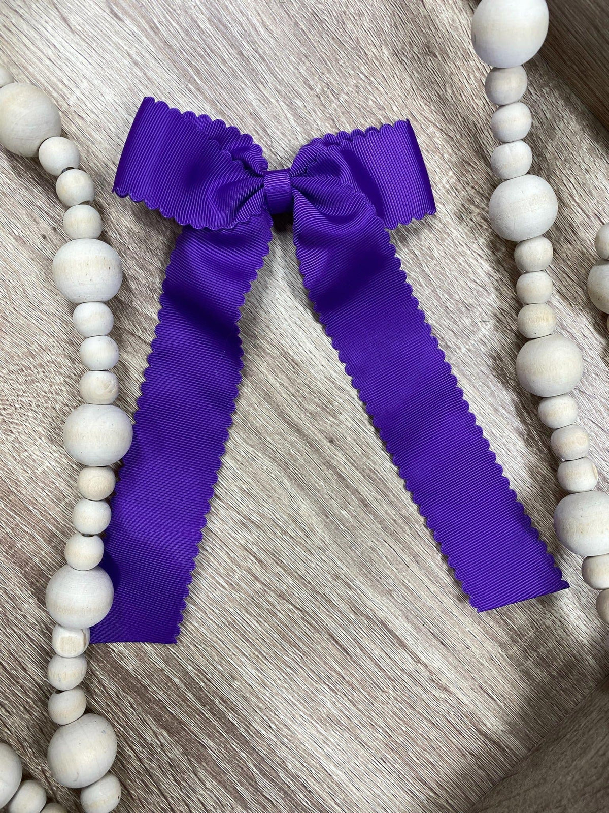Purple scalloped long tail hair bow on alligator clip