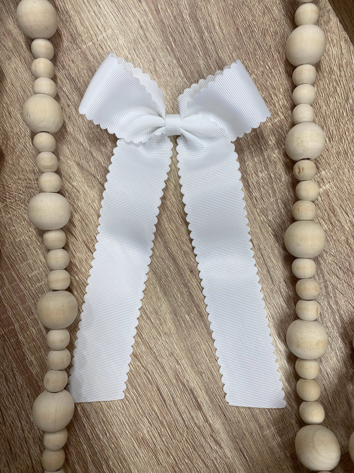 White scalloped long tail hair bow on alligator clip
