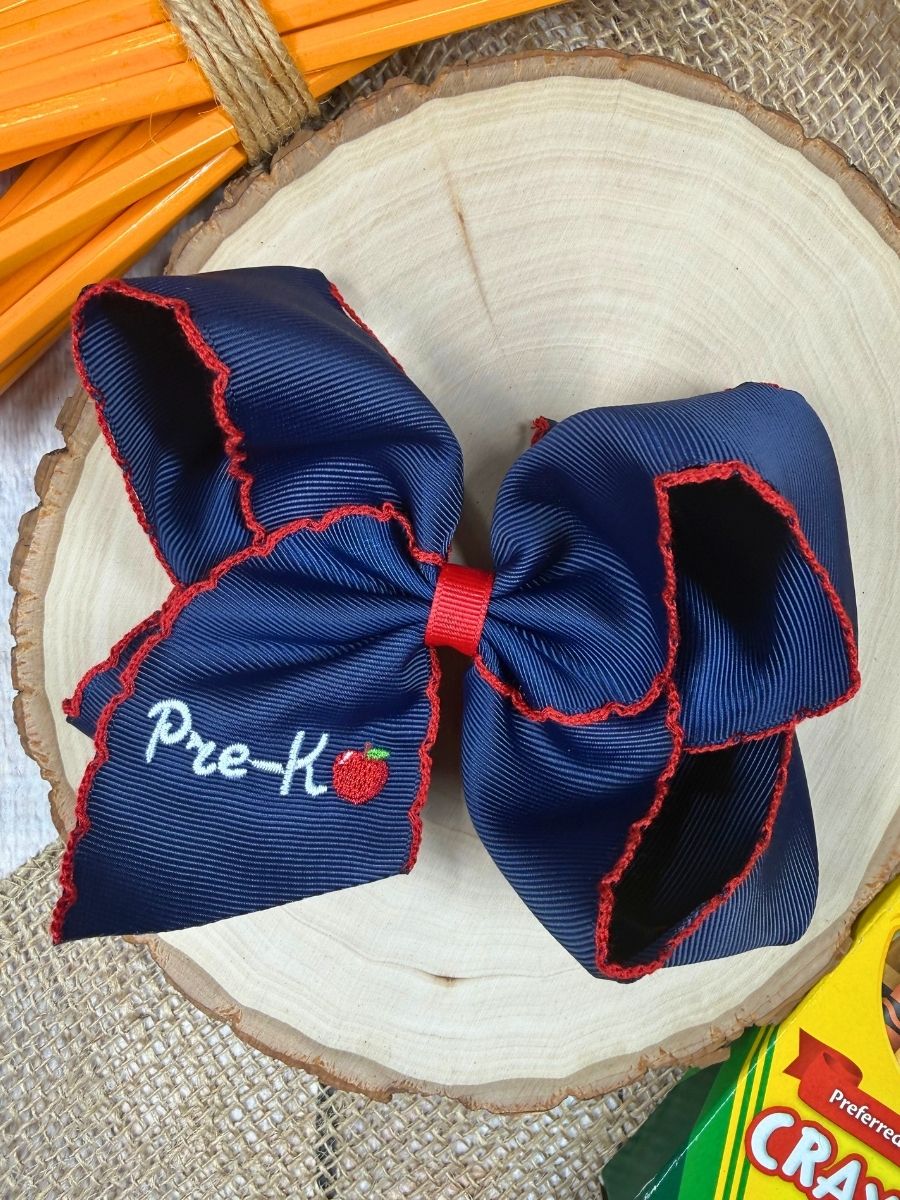 Navy blue pre-K bow with red trim on a wooden surface