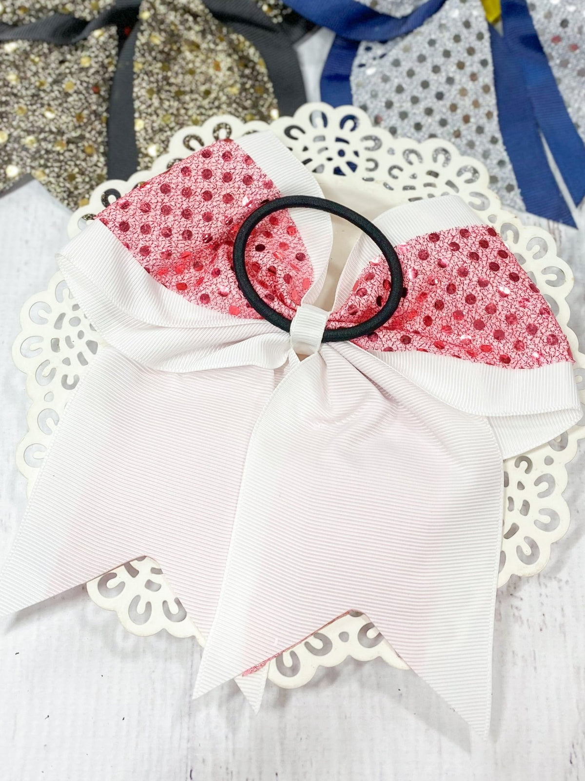 Pink and white sequin cheer bow on a black pony-o