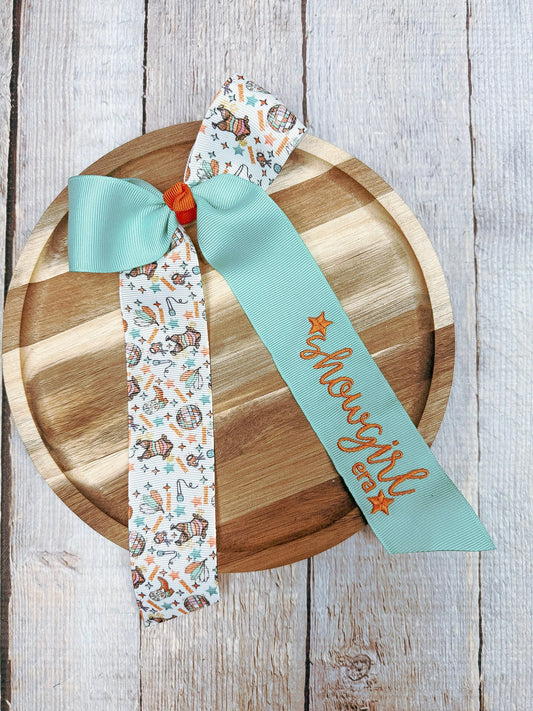 Showgirl era bow on wooden surface - Alternative view