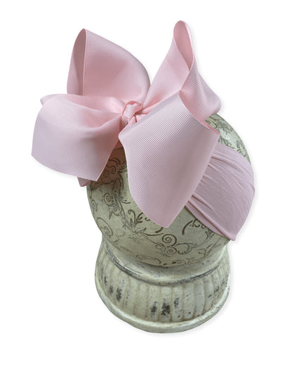 Soft nylon interchangeable headband shown with a pink hair bow