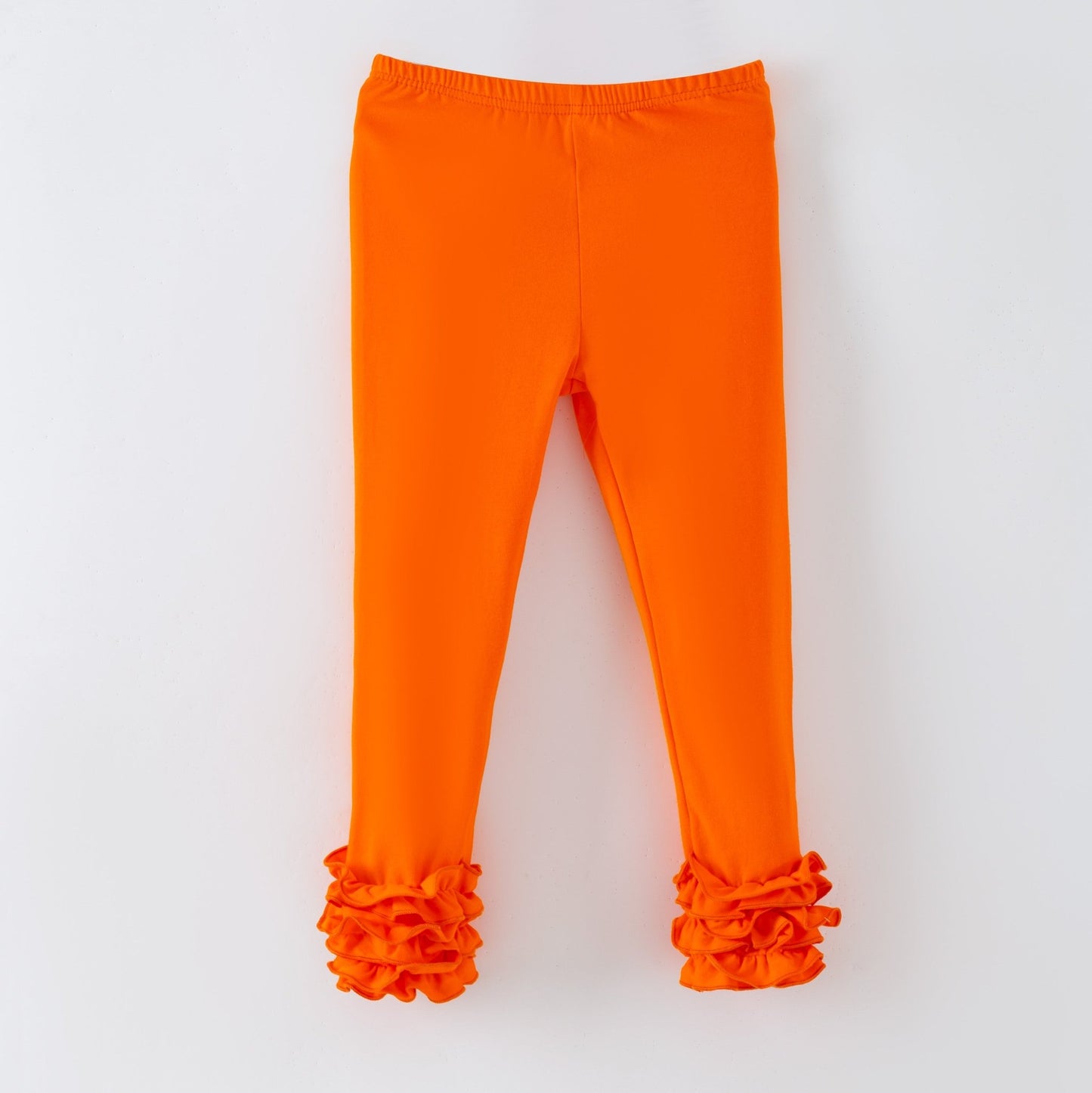 Orange leggings with ruffled cuffs on a white background