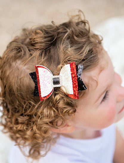 Girl wearing a sparkly Santa belt bow clippie