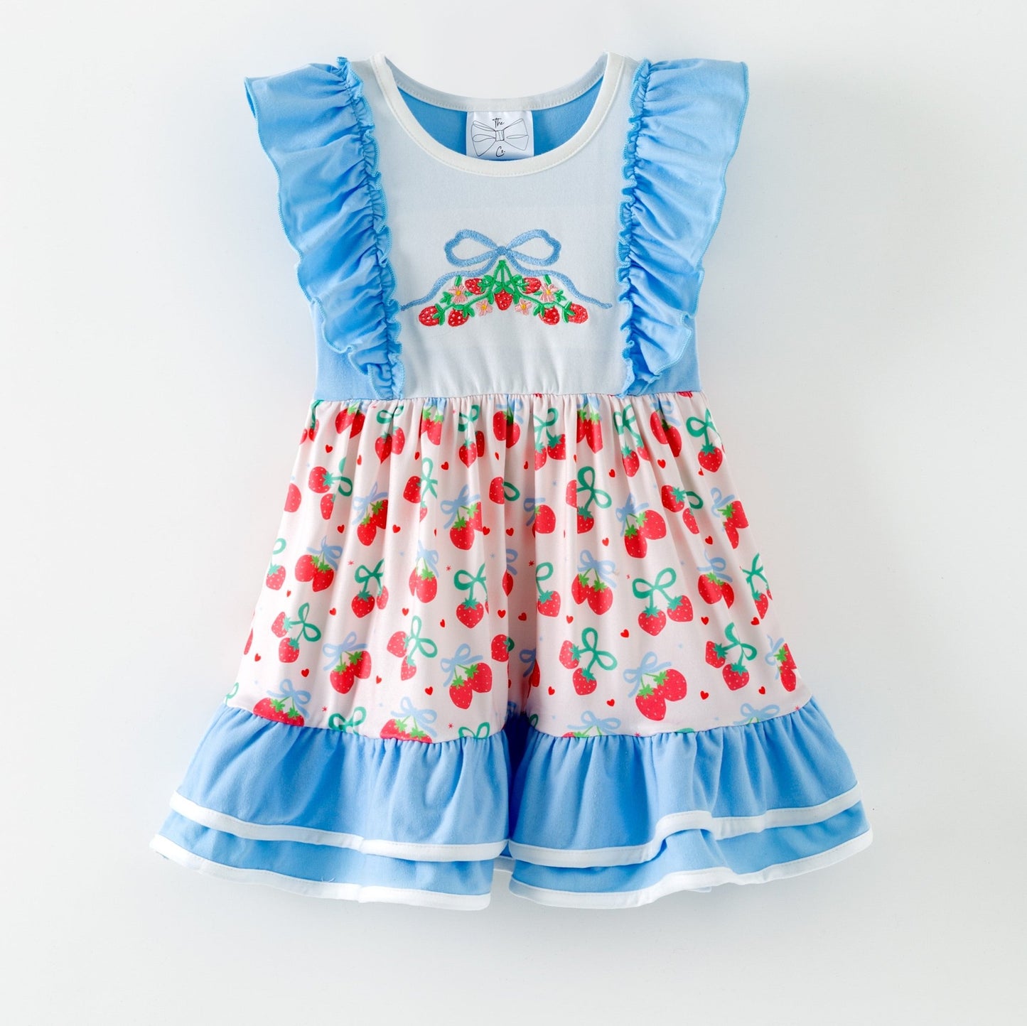 Children's dress with cherry pattern and blue ruffles on a white background
