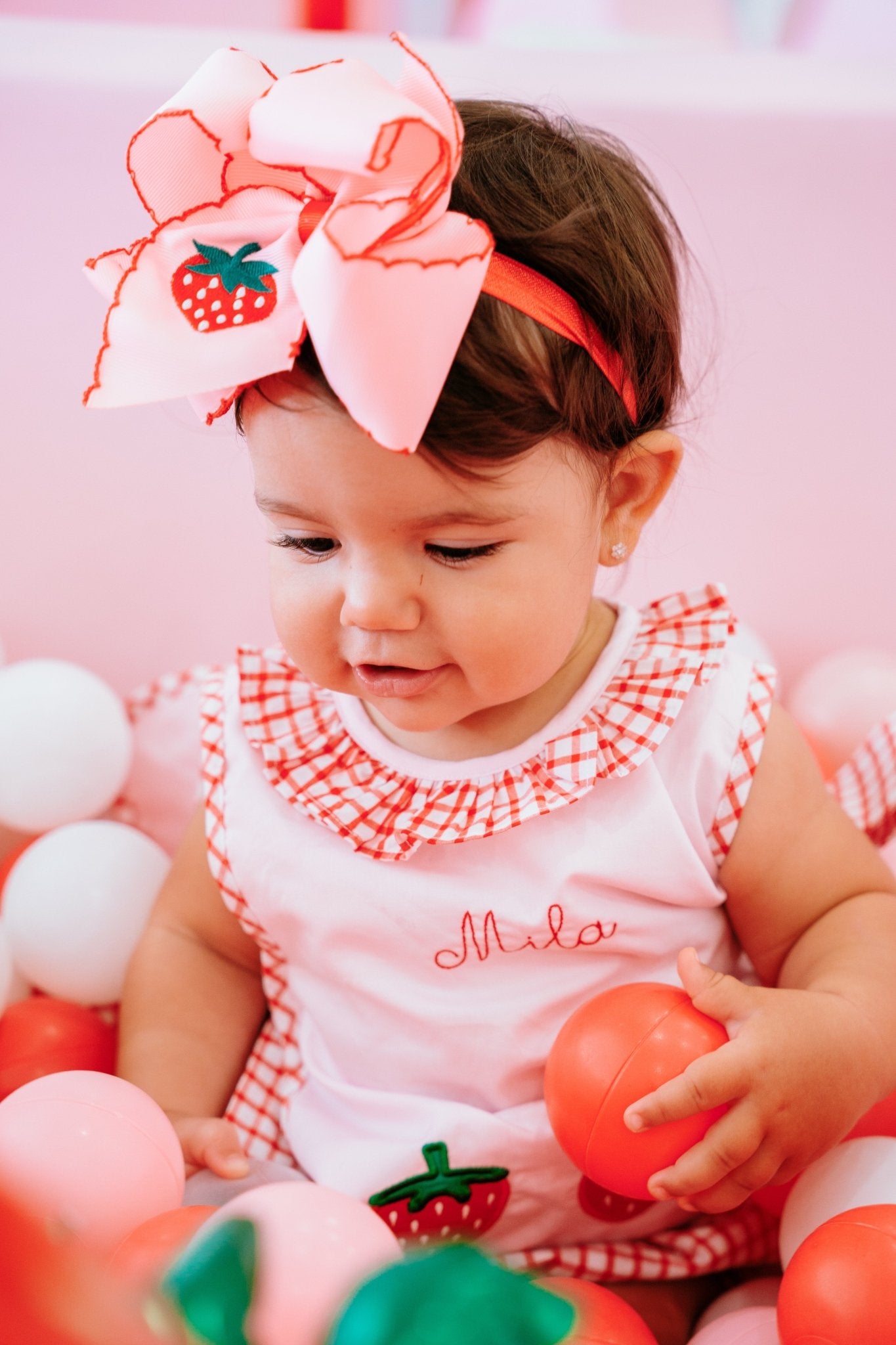 infant model wearing strawberry bow headband