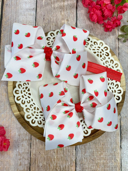White strawberry print hair bow with red center knot on clip or headband