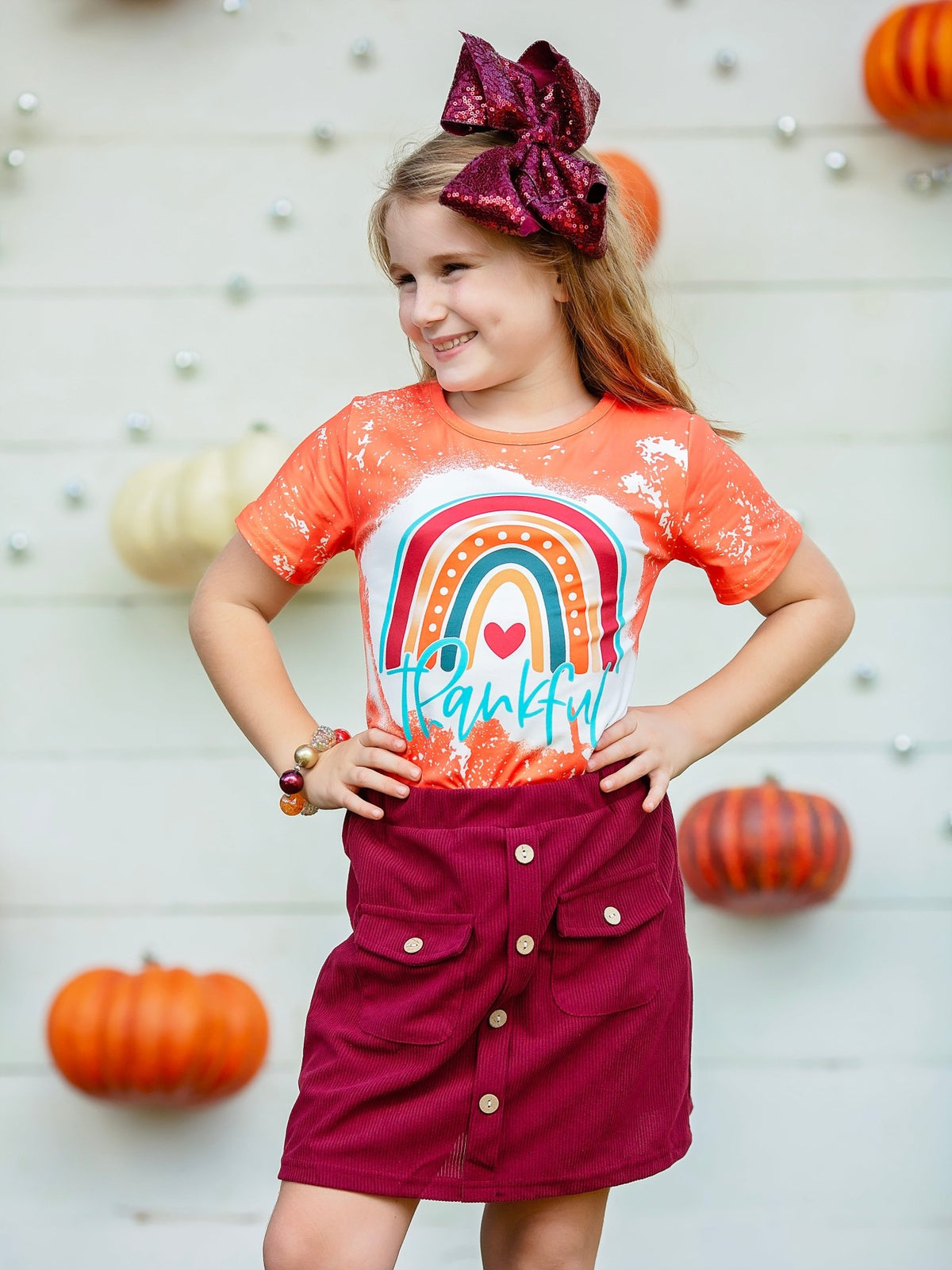 Girl wearing the orange Thankful rainbow tee