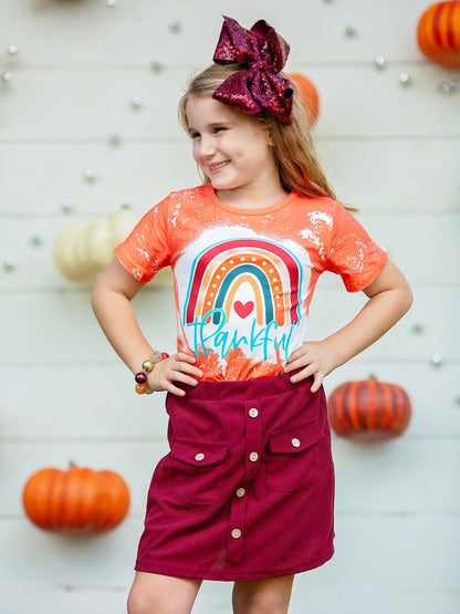 Girl wearing the orange Thankful rainbow tee