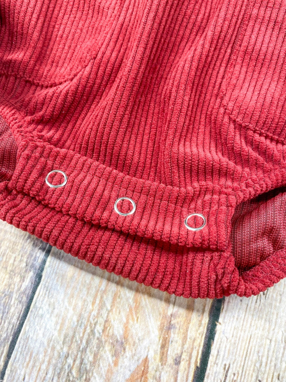 Close-up of the snaps at the bottom of the corduroy romper