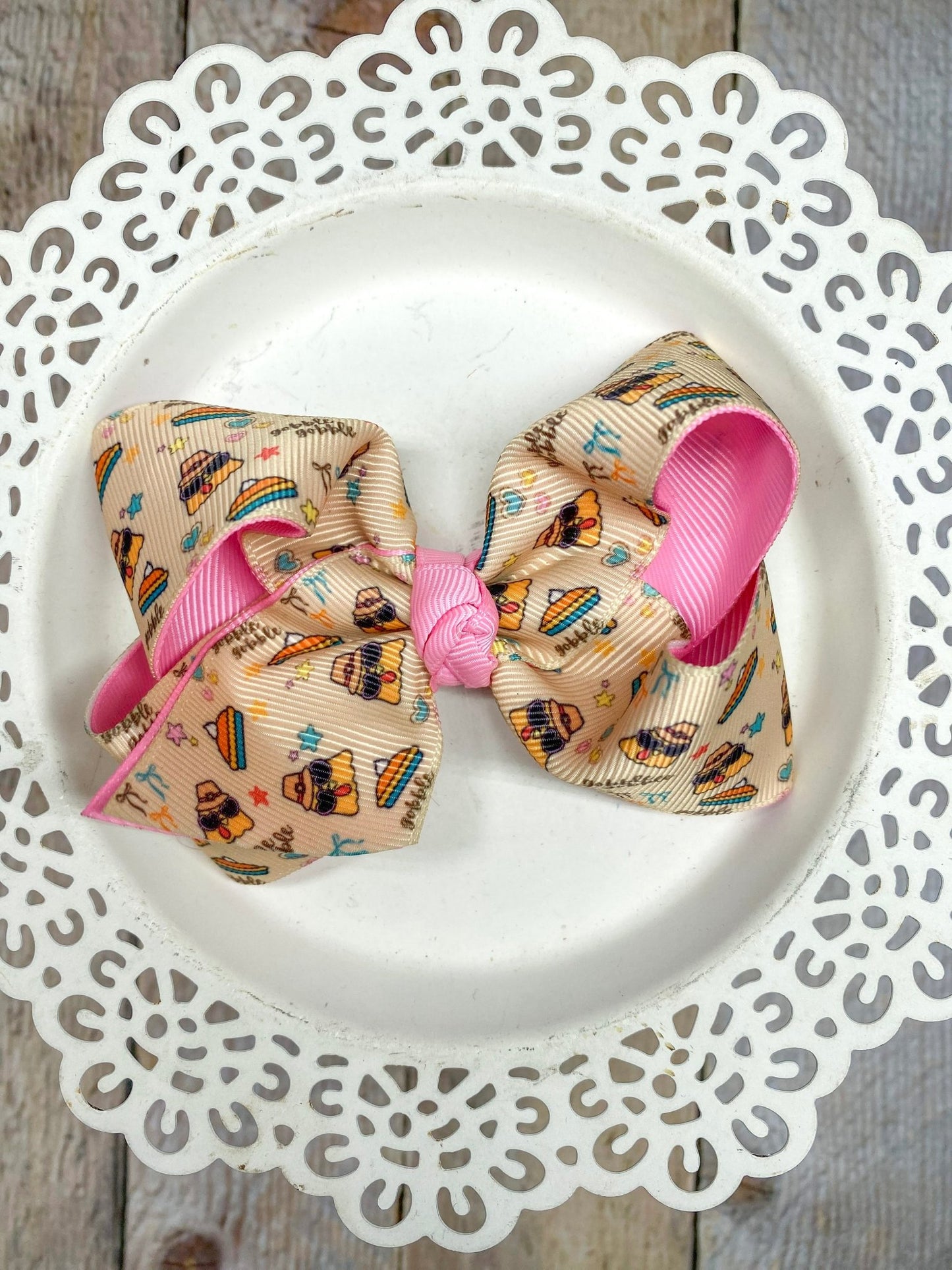double layer bow with inside later being a bright pink and a fun print over an oatmeal background with funky turkeys and pies and stars