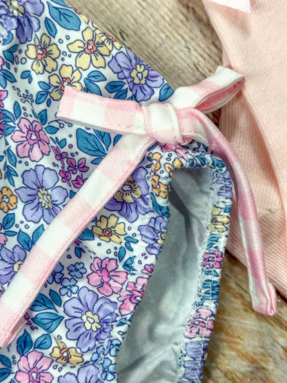 close up of gingham bow tie on side of floral bottoms of romper