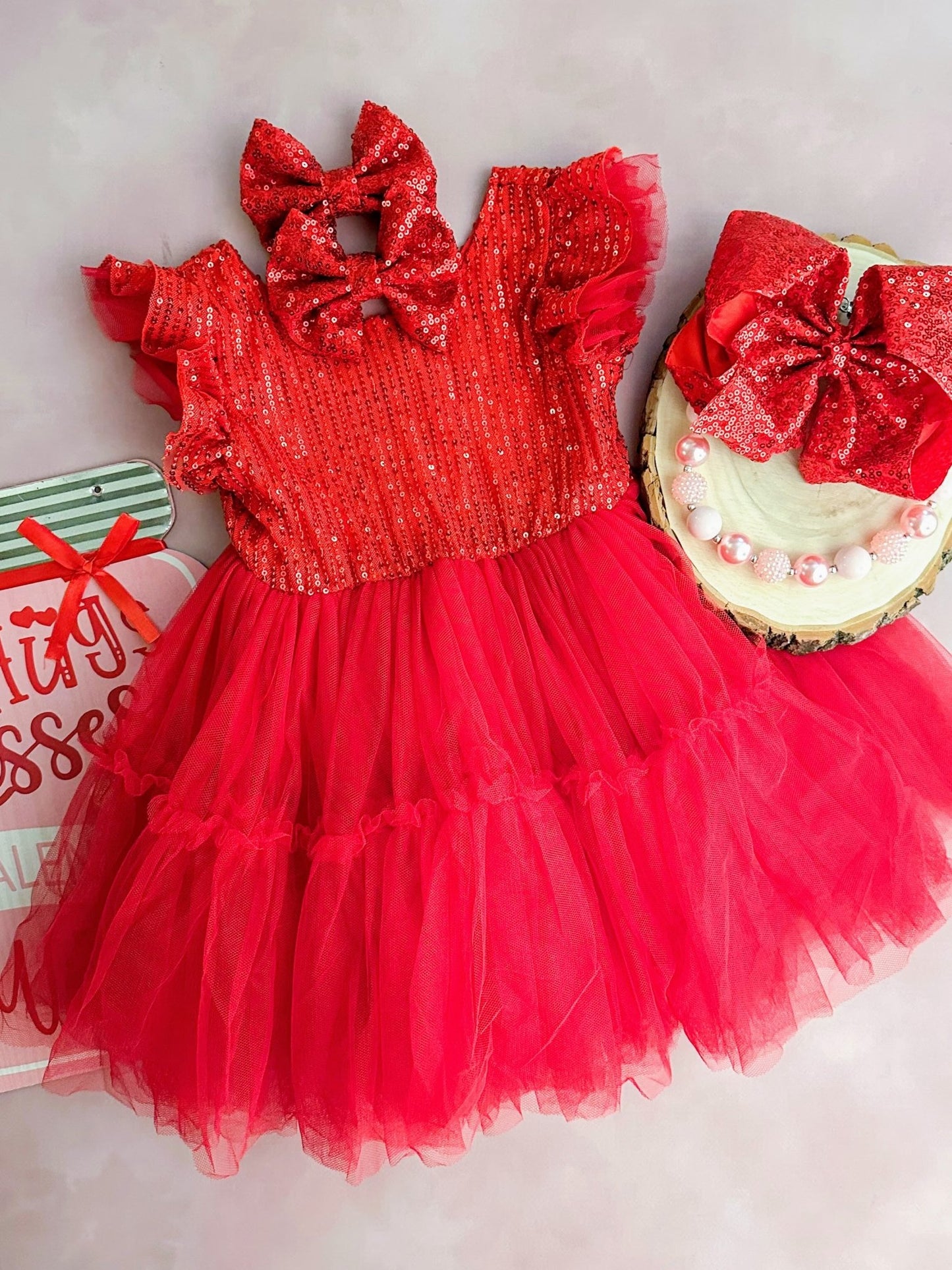 Red sequin dress with a large bow on a light background