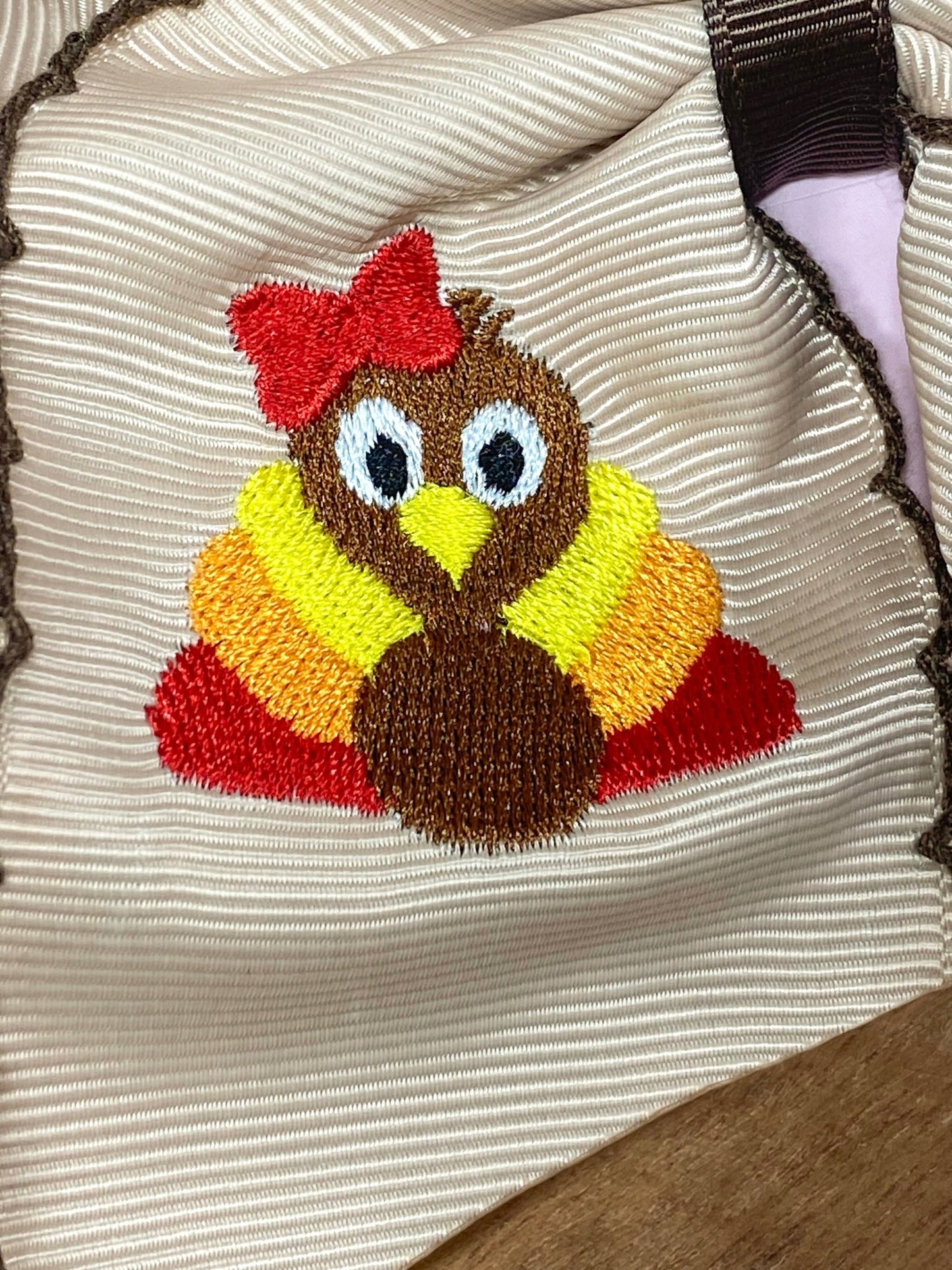 Close up of turkey embroidery on moonstitch bow headband