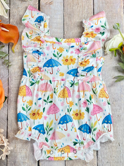 umbrella baby romper on wood surface with flowers