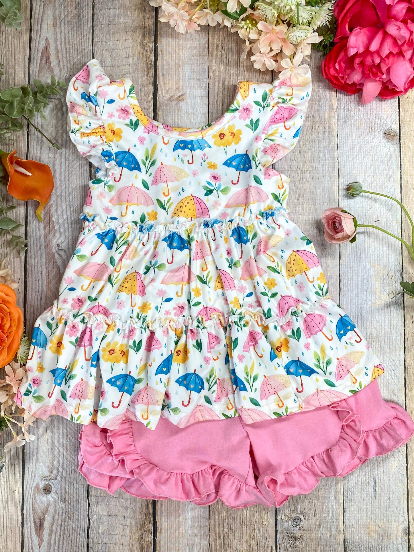 Umbrella print ruffle top and shorts set on decorative wood