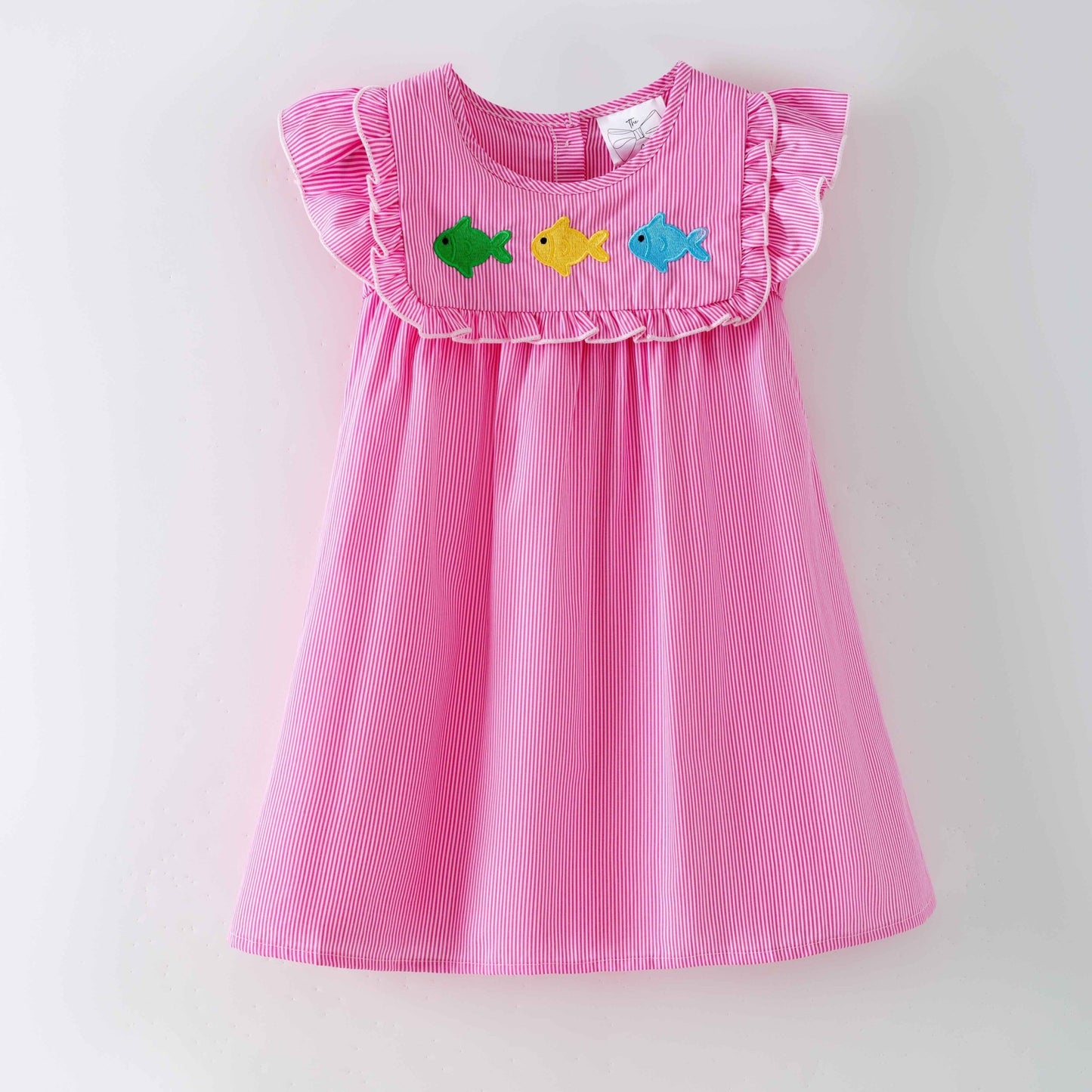 Pink dress with colorful fish appliqués on a white background