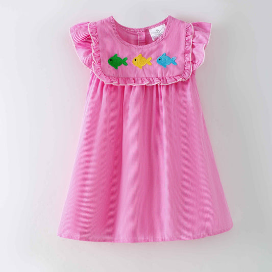 Pink dress with colorful fish appliqués on a white background