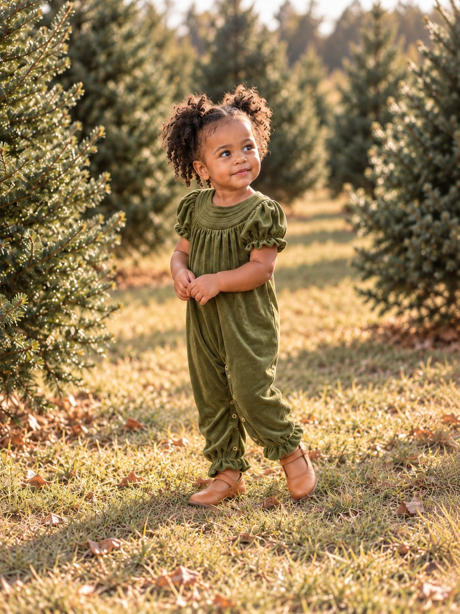 model wearing our Baby girl smocked velvet holiday romper with Christmas trees