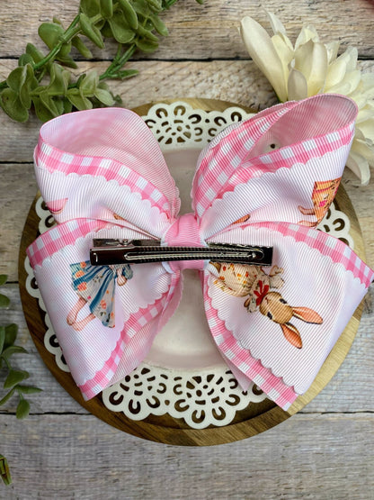 Large decorative bow with a hair clip on a wooden surface with floral decorations.