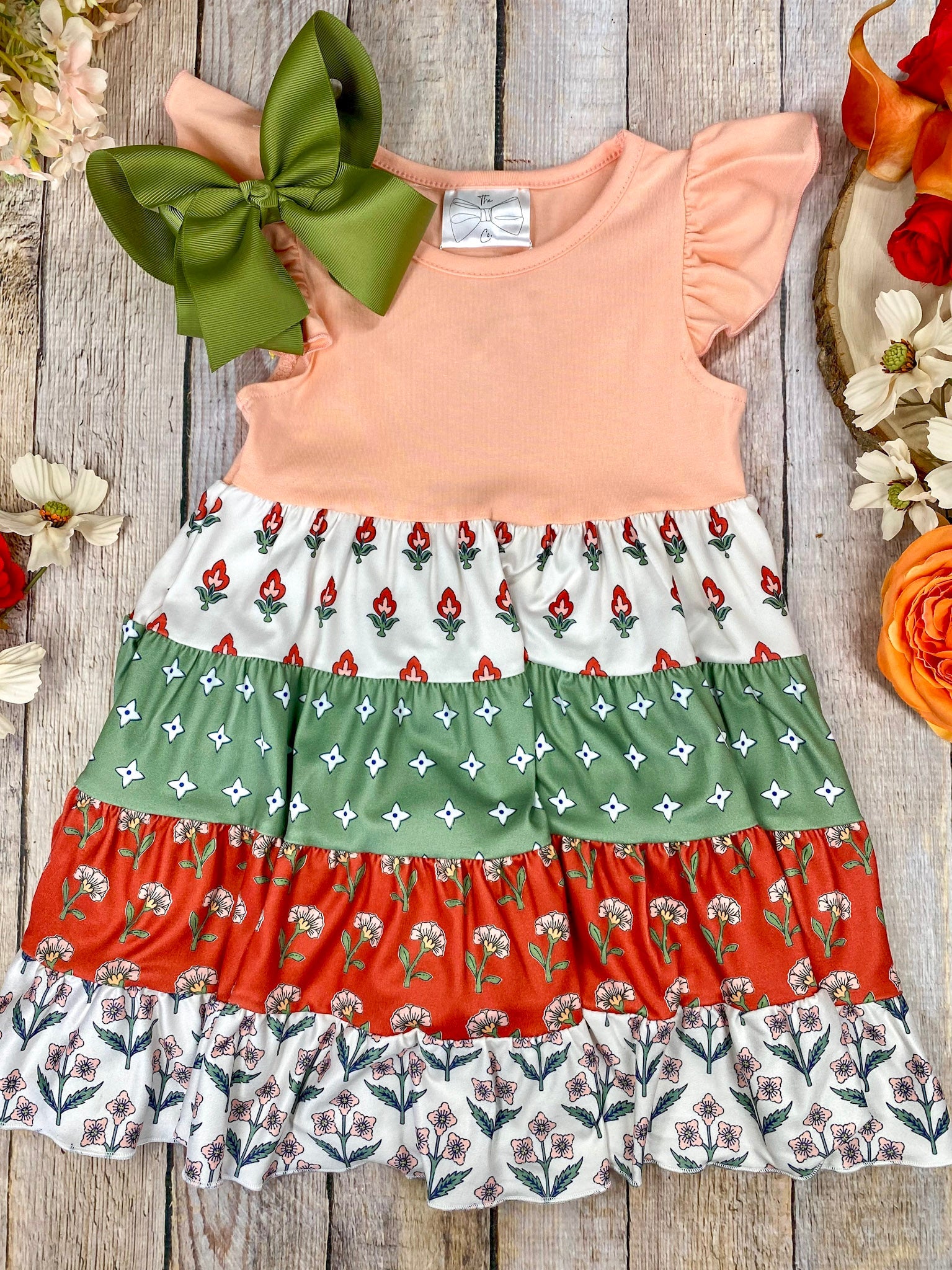 Boho Coral Boutique Girls Tiered Dress on a wooden background