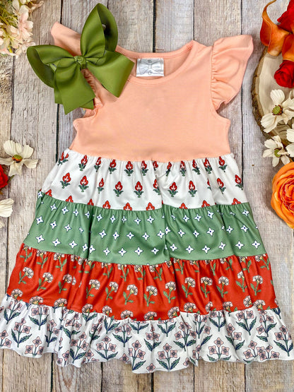 Boho Coral Boutique Girls Tiered Dress on a wooden background